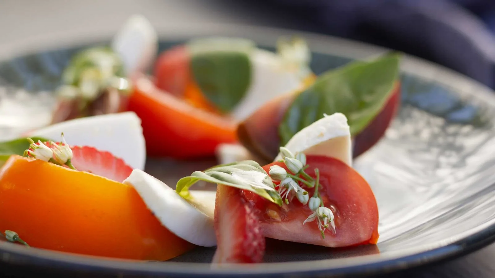 plate of dices tomatoes, cheese, and basil