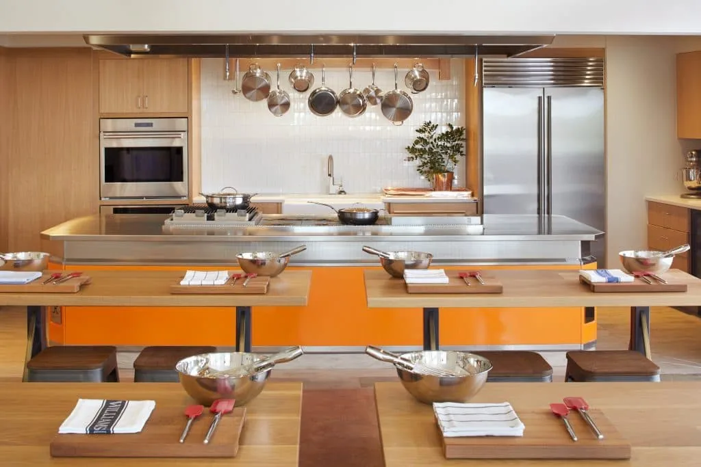 Kitchen for cooking class with counter and pants and table for students with mixing bows and baking utensils